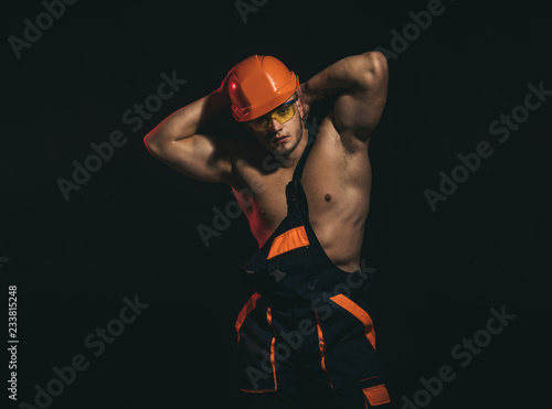 My work will be sure to impress. Construction worker or builder. Man worker with muscular sexy body. Handsome worker or workman. Muscular man wear hard hat and uniform. Confident and strong