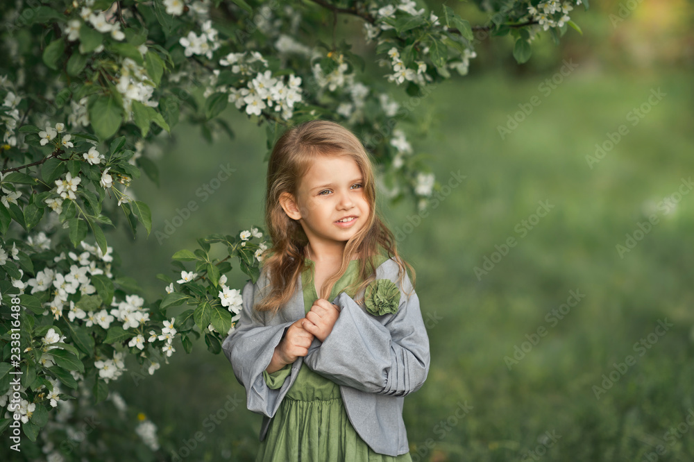 Fototapeta premium Portrait of a little girl in spring in flowering trees 1805.