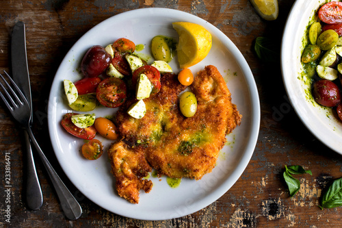 Close up of chicken Milanese with tomato, mozzarella salad photo