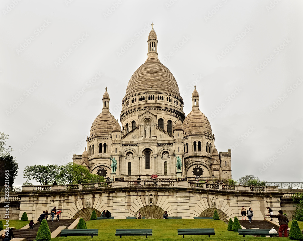 Vista desde un ángulo bajo de la fachada frontal de la Basílica del Sagrado Corazón de Montmartre en París, Francia. Día gris y nublado como fondo. 