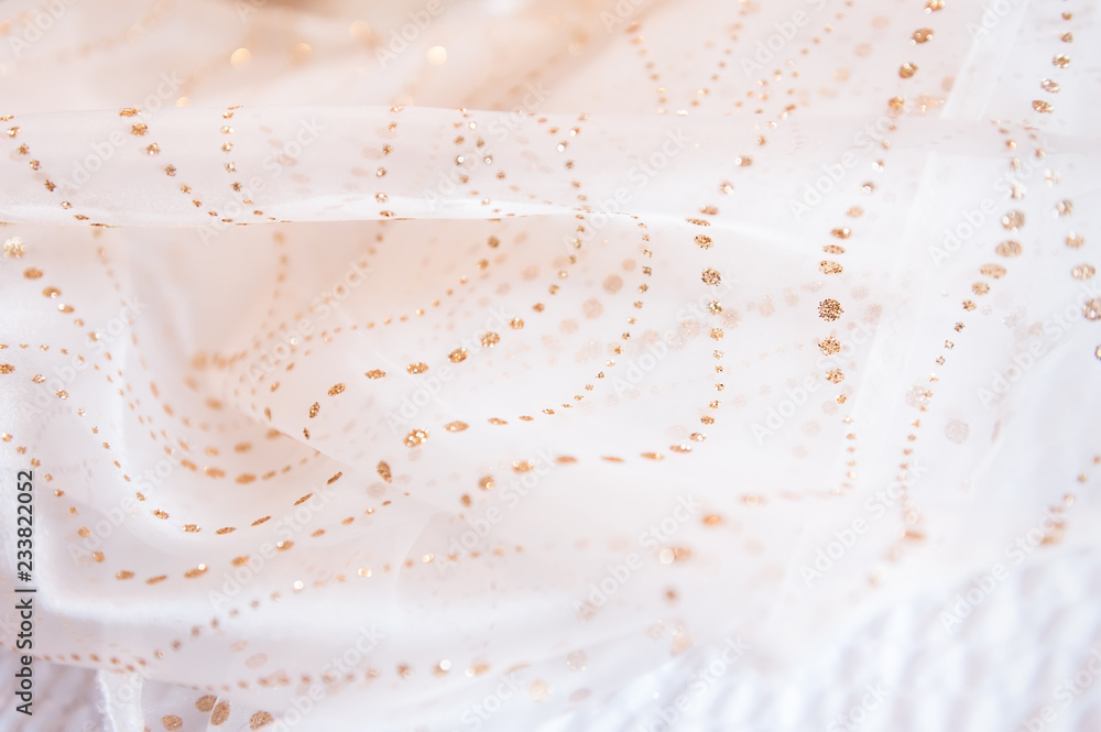 A close up abstract view of a scarf with golden dot details. A close up abstract view of a scarf with golden dot details.