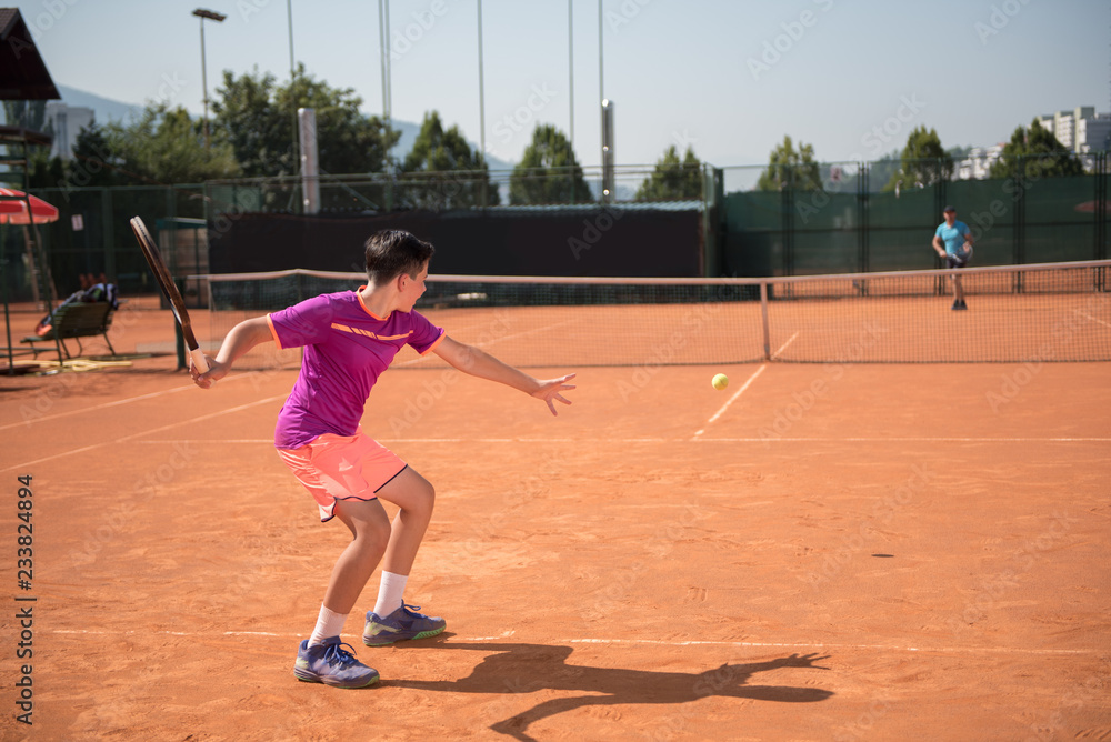 Young tennis player playing forehand