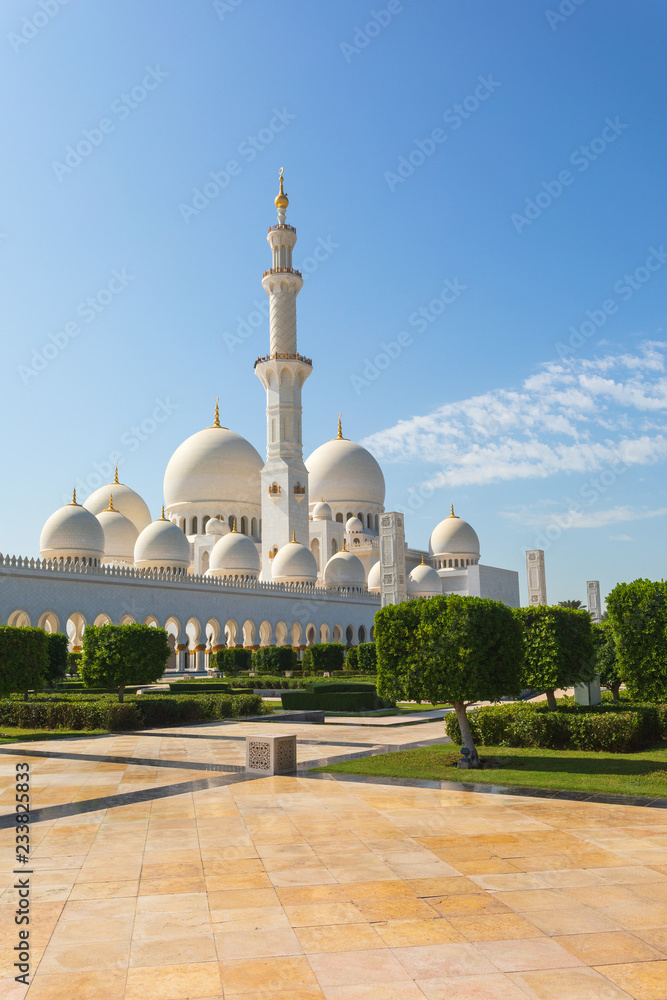 Fototapeta premium Sheikh Zayed Mosque - Abu Dhabi, United Arab Emirates. Beautiful white Grand Mosque view from exerior of one of the 4 minarets and part of the garden.