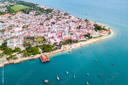 Stone Town, old colonial center of Zanzibar City. House of Wonders. Old Fort. Azure sea and stunning yellow beaches. Unguja island, Tanzania. Aerial.