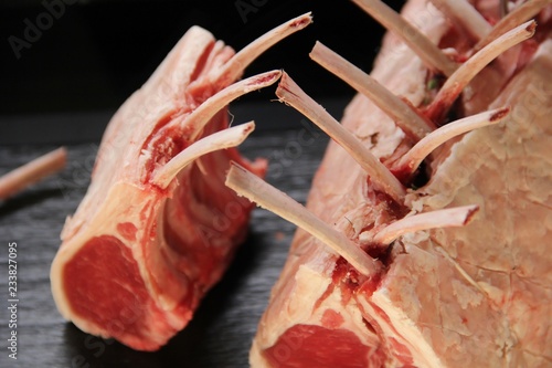 Raw lamb rack or loin of lamb at the butchers. Fresh lamb meat on the bone as crossed ribs joned together. A delicacy as tasty baked or roast gourmet dinner for Christmas celebrations. Selective focus