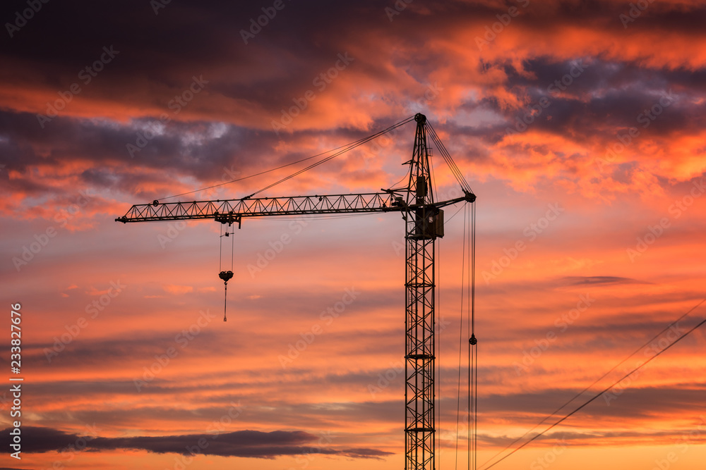 Boom crane on the background of fiery sunset sky, a part of industrial construction Boom crane on the background of fiery sunset sky, a part of industrial construction