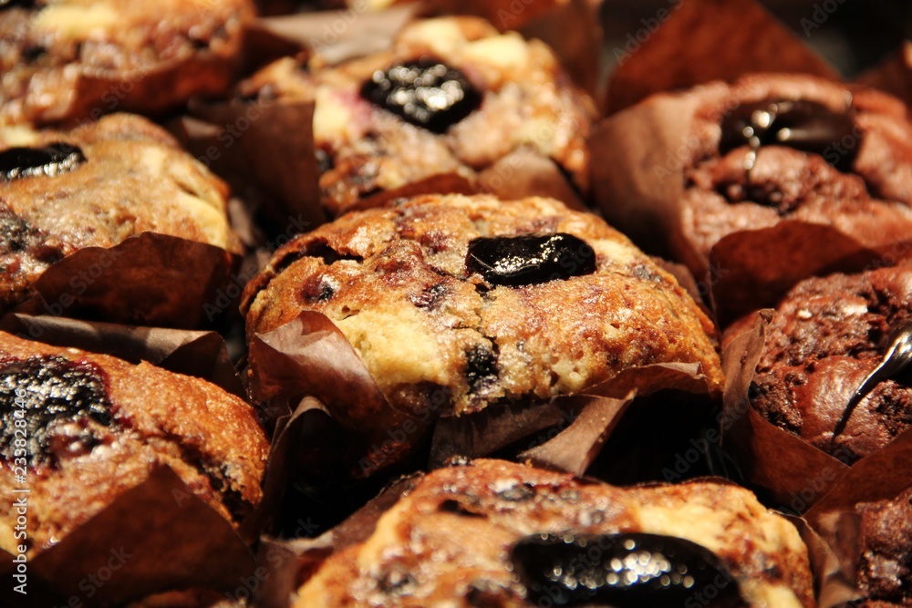 Chocolate chip and blueberry muffins with dark marmalade topping or filling. Warm homemade muffins or cupcakes at a bakery around Christmas. Sweet, delicious and tasty dessert for tea time in winter