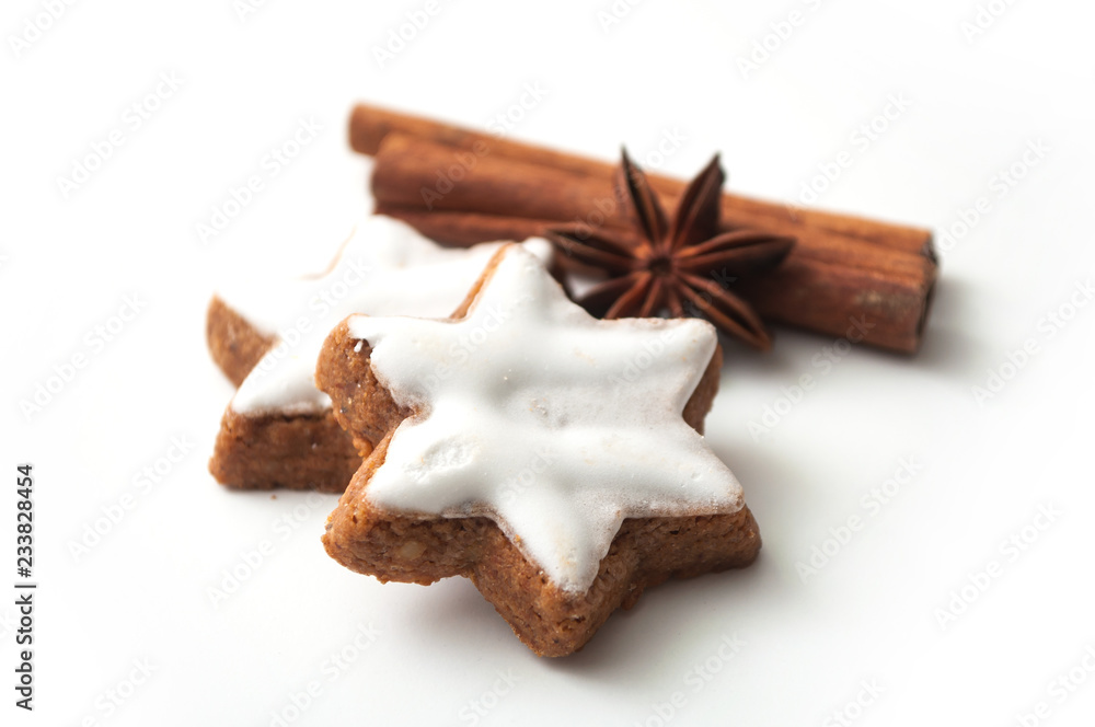 closeup of christmas biscuit shaped star with anise flower and cinnamon stick on white background closeup of christmas biscuit shaped star with anise flower and cinnamon stick on white background