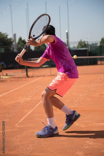 Young tennis player playing backhand