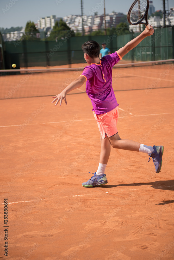 Young tennis player playing backhand