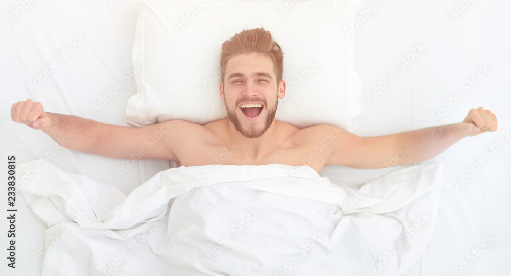top view. happy man waking up in a comfortable bed top view. happy man waking up in a comfortable bed