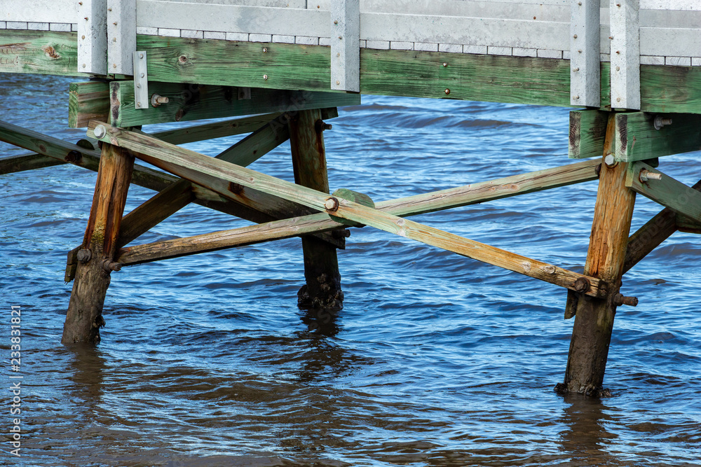 Wooden cross beam supports holding up walkway in lake water - Anne Kolb / West Lake Park, Hollywood, Florida, USA Wooden cross beam supports holding up walkway in lake water - Anne Kolb / West Lake Park, Hollywood, Florida, USA