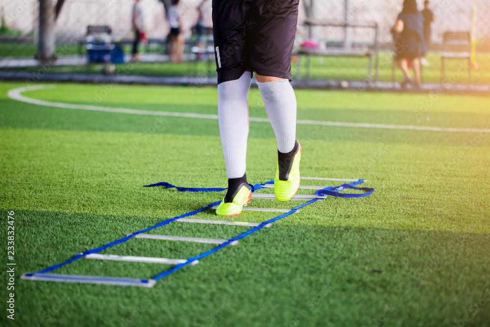 Young boy soccer players Jogging and jump between ladder drills for football training. Young boy soccer players Jogging and jump between ladder drills for football training.