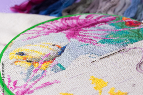 The process of working on a piece of embroidery.
