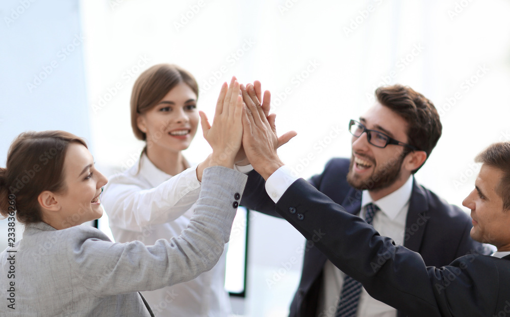 successful business team giving each other a high-five, standing in the office successful business team giving each other a high-five, standing in the office