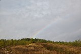 View of the surrounding hills and meadows in autumn, rainbow.