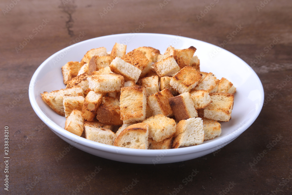 Delicious crispy croutons, crumbs of bread in white plate. ready for cooking.