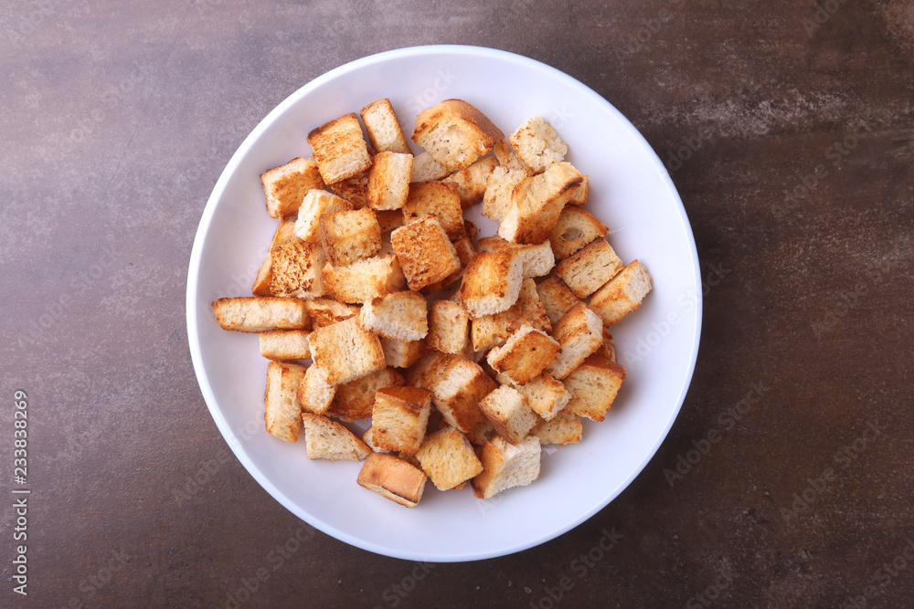 Delicious crispy croutons, crumbs of bread in white plate. ready for cooking. Delicious crispy croutons, crumbs of bread in white plate. ready for cooking.