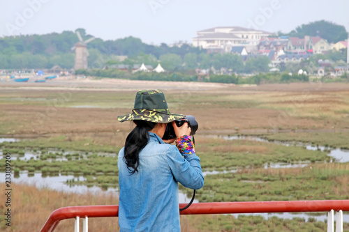 A female photographer was photographing in a wetland park, china © zhang yongxin