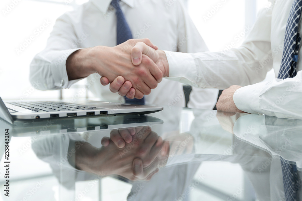 close up.colleagues shaking hands over a Desk close up.colleagues shaking hands over a Desk