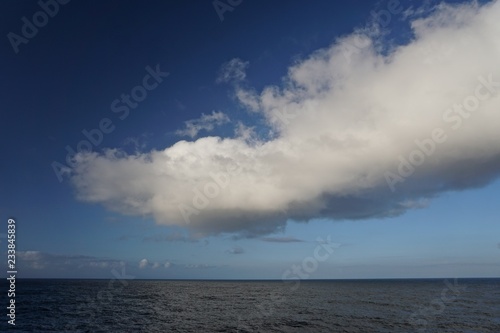 Thick white clouds over the horizon in a deep blue sky somewhere in the North Pacific Ocean between Sitka, Alaska, and Victoria, British Columbia, Canada. © Linda Harms