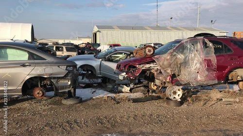 Auto salvage yard for body parts on vehicles pan left to right.  