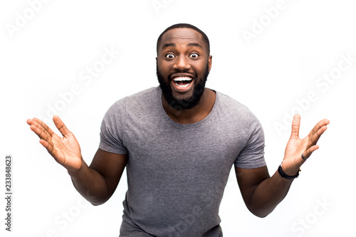 Amazing news, happy moment. Surprised young African American man have his resalt on exams. So happy, enjoying moment and having fun. Laughing and looking amazed. Isolated on white studio background photo