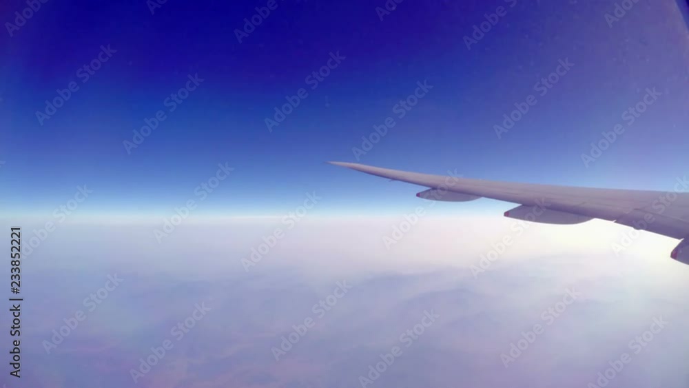 wing of airplane flying above clouds wing of airplane flying above clouds