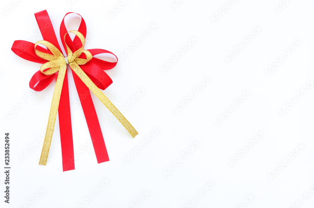 red and gold satin bow ribbon at the corner on white background red and gold satin bow ribbon at the corner on white background