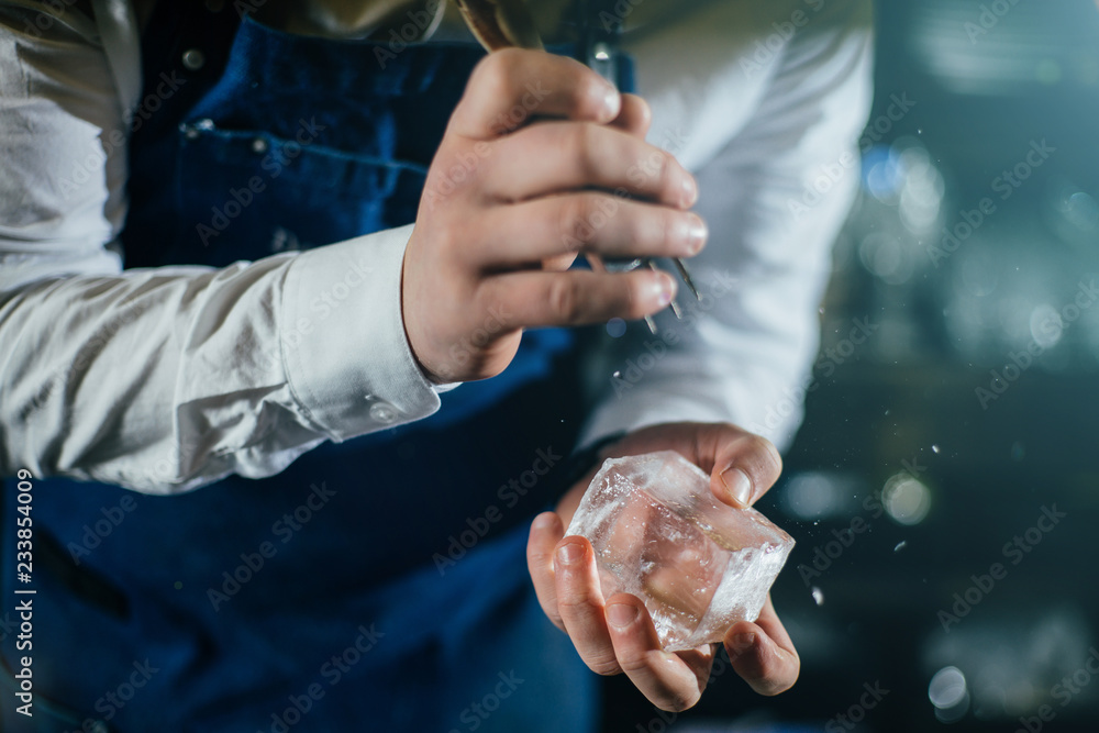 Bartender professionally working with ice to make cold good drinks