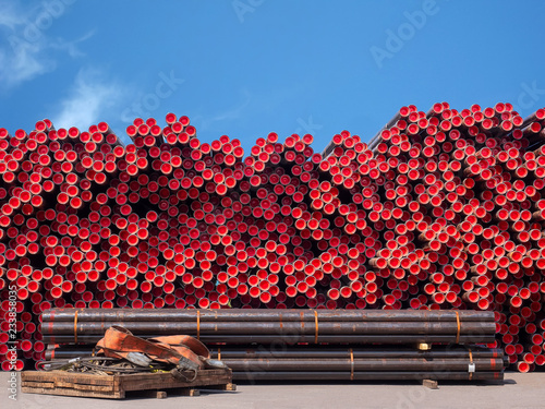 Stacking of oil and gas drill pipe in outdoor yard. photo