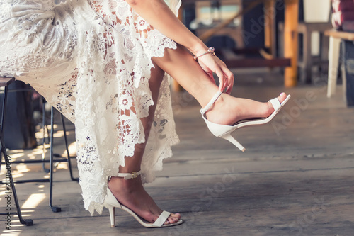 bride put on wedding shoes on her feet