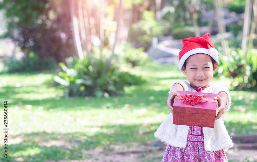 Asian child little girl in santa red hat with gift box