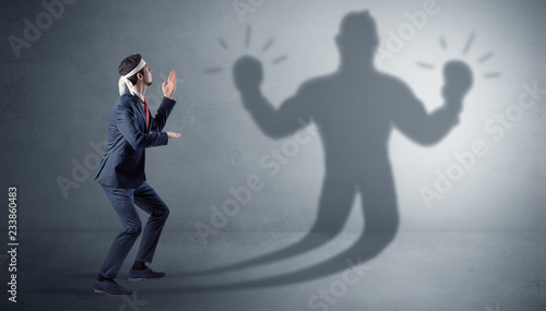 Businessman trying to fight with his unarmed shadow   © ra2 studio