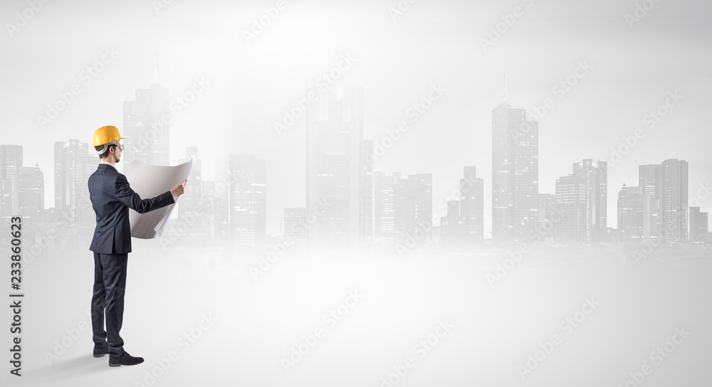 Young supervisor architect standing and looking at a big city panorama
Young supervisor architect standing and looking at a big city panorama