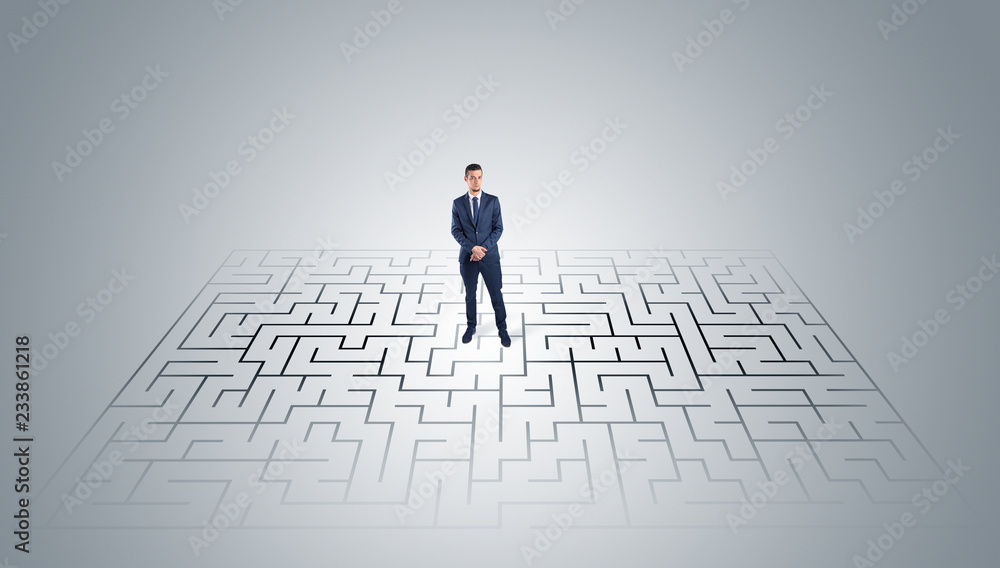 Elegant businessman looking for a solution in a middle of a maze
Elegant businessman looking for a solution in a middle of a maze