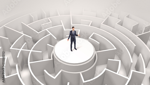 Businessman standing on the top a maze and looking through 