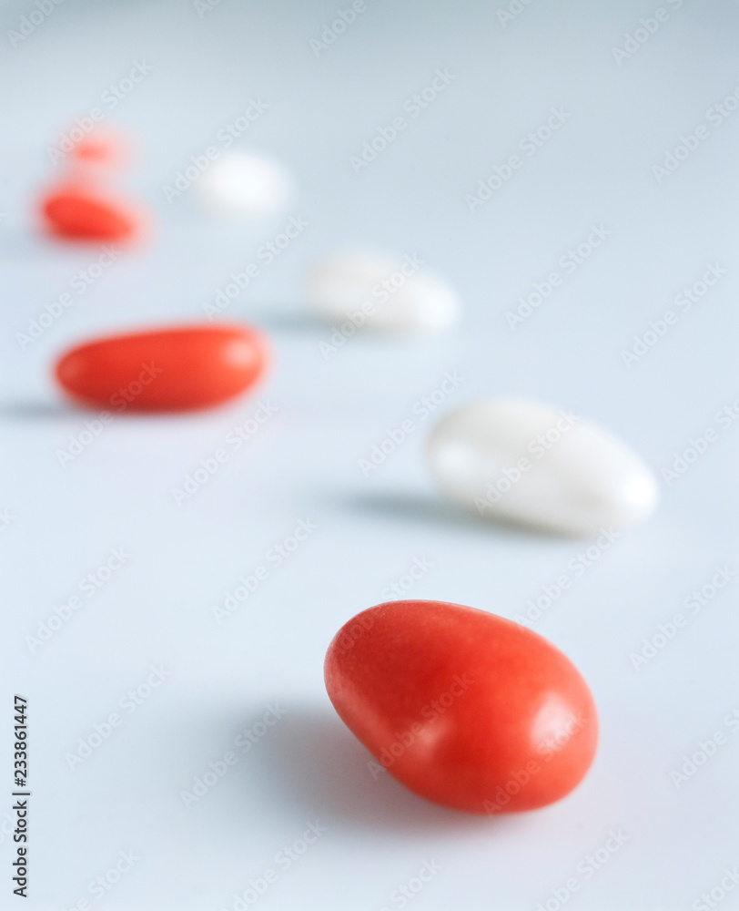 White and red candy-coated almonds still life composition imitating steps White and red candy-coated almonds still life composition imitating steps