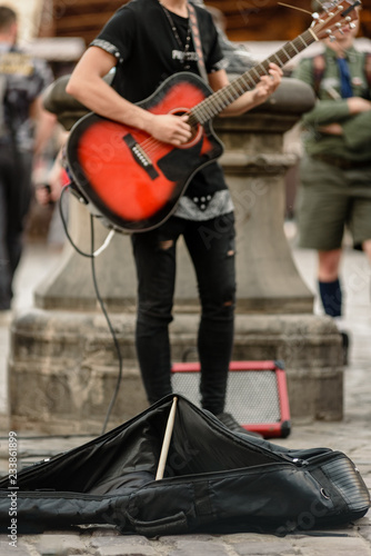 Street musician playing guitar for tourists on city center