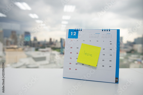 Leave on paper note stick on the calendar of December for year end holidays concept