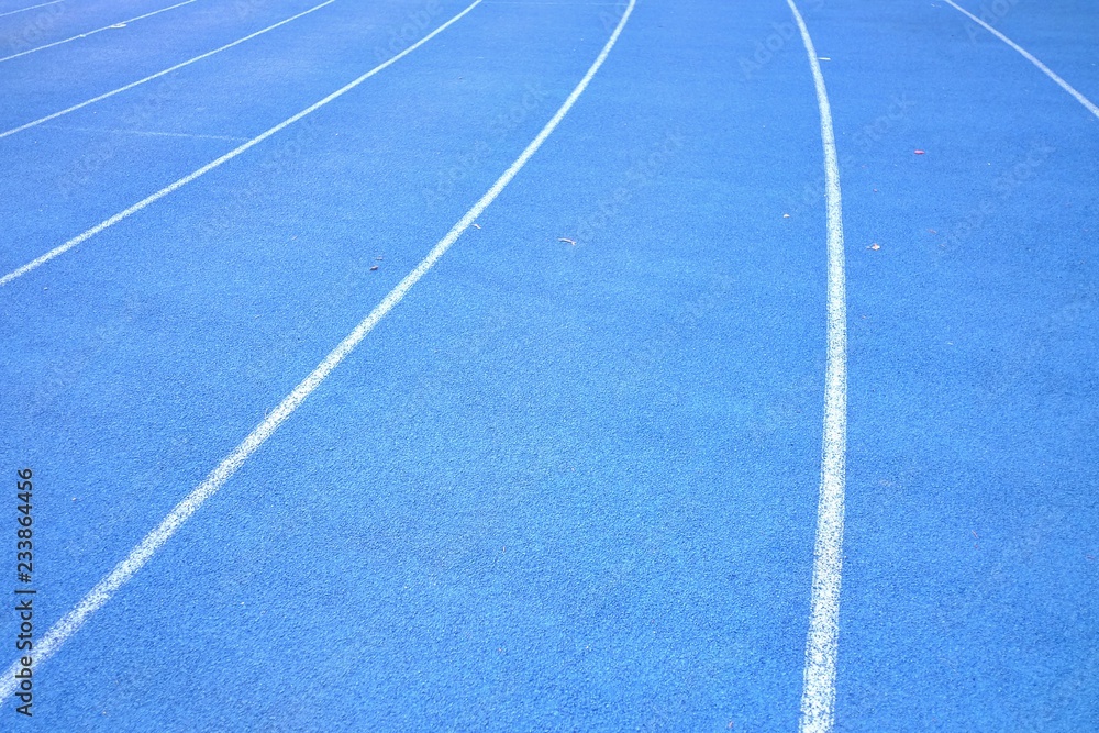 Close up blue running lane with a white curve for background texture 