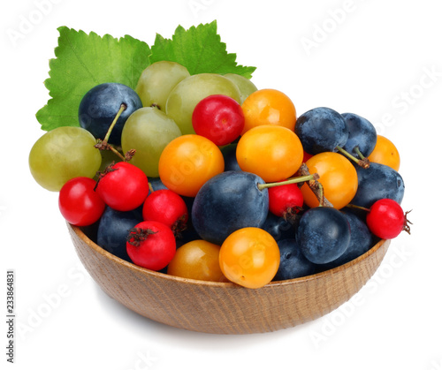 Fruits of grapes  hawthorn  cherry plum  plum in a wooden cup isolated on white