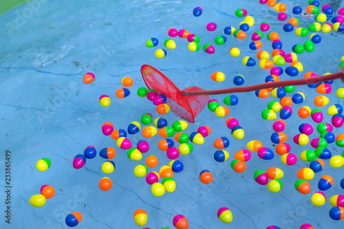 Colorful plastic eggs game with lucky toys inside floating on the water background.