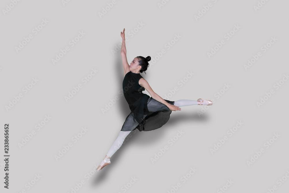 Asian ballet dancer doing jump exercises on studio