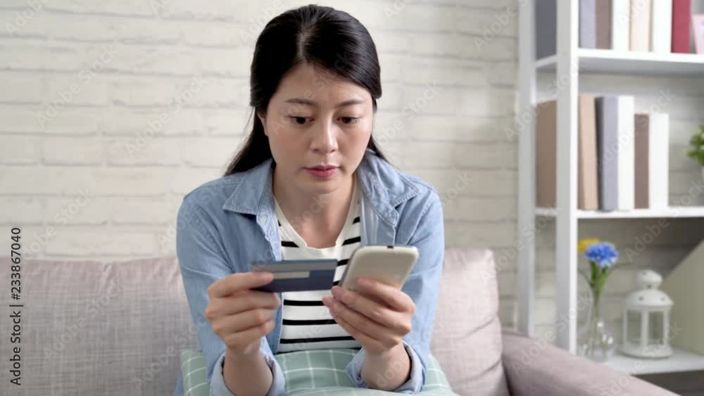 asian woman shopping on online shoes store with credit card on big bargain sale. Pretty lady buying clothes with special price on internet shop. young girl using cellphone on sofa. asian woman shopping on online shoes store with credit card on big bargain sale. Pretty lady buying clothes with special price on internet shop. young girl using cellphone on sofa.