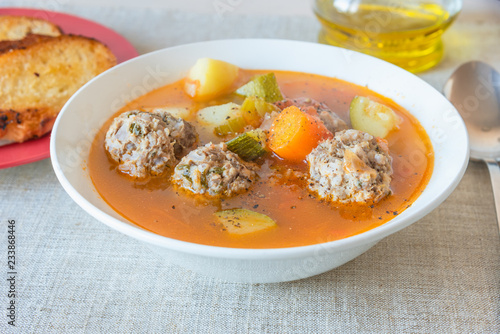 Mexican vegetable soup with meatballs Albondigas in a plate close-up.