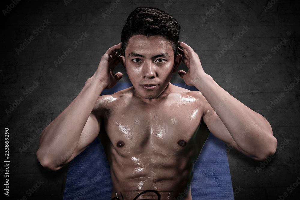 Handsome man doing crunches exercises on the mat