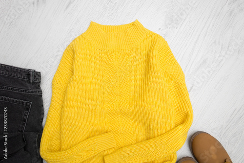 Yellow sweater closeup on wooden background