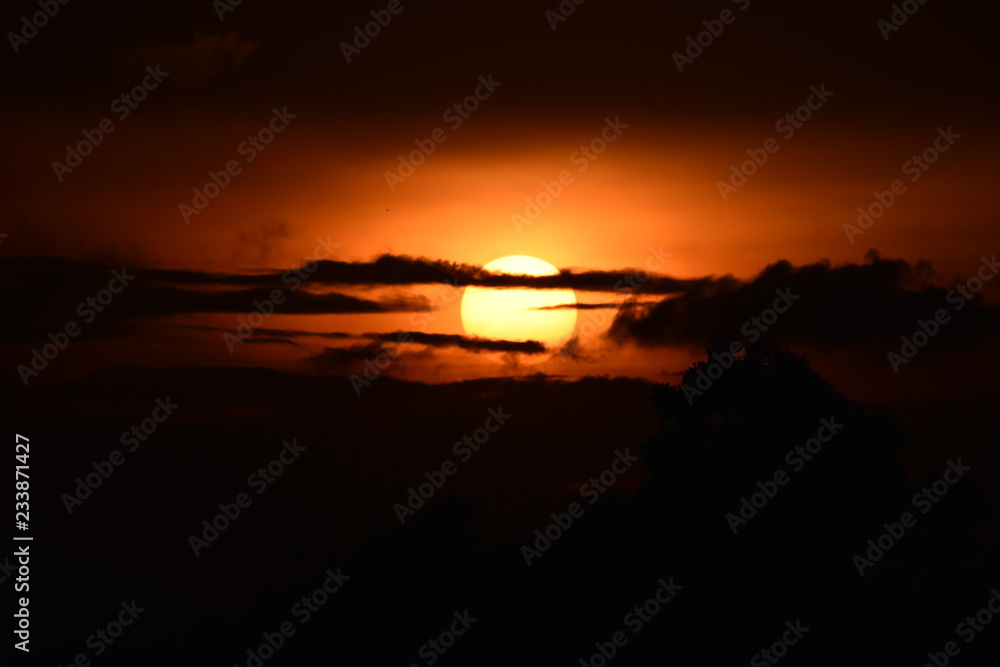 Brilliant orange sunrise over clouds in Iowa with bright yellow sun on a cool spring morning. Brilliant orange sunrise over clouds in Iowa with bright yellow sun on a cool spring morning.