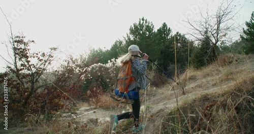 Wallpaper Mural Girl with a backpack tourist climbs a rock and jumps over the сreek. The concept of victory and tourism, goal achievement, slow motion Torontodigital.ca